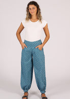 Model has hands in pockets of blue cotton printed pants