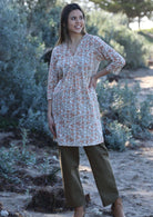 Model wears tunic with 3/4 sleeves