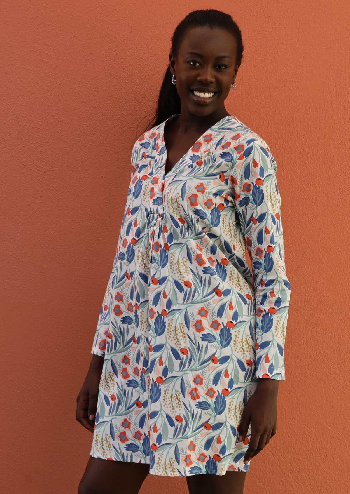 Model wears long sleeve cotton tunic with V-neckline
