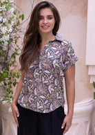 Model wears light brown floral cotton relaxed fit top with folded cuffs and a collar
