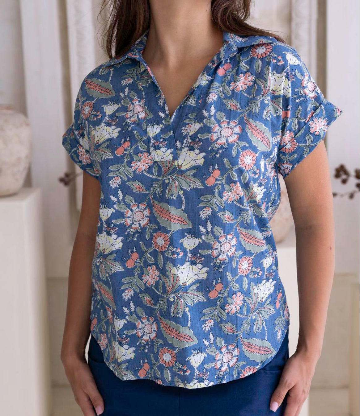 100 percent cotton relaxed fit dusty blue based floral top with short folded cuff sleeves, collar and V neckline