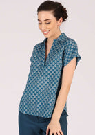 Model wears a blue relaxed fit top with a v neckline made from 100% cotton. 