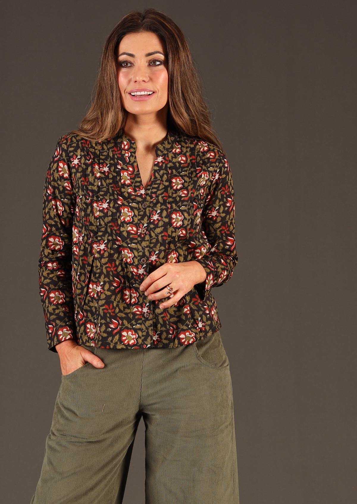 Model in Asha Top Wild Rose black floral print cotton blouse worn with green corduroy wide legged pants