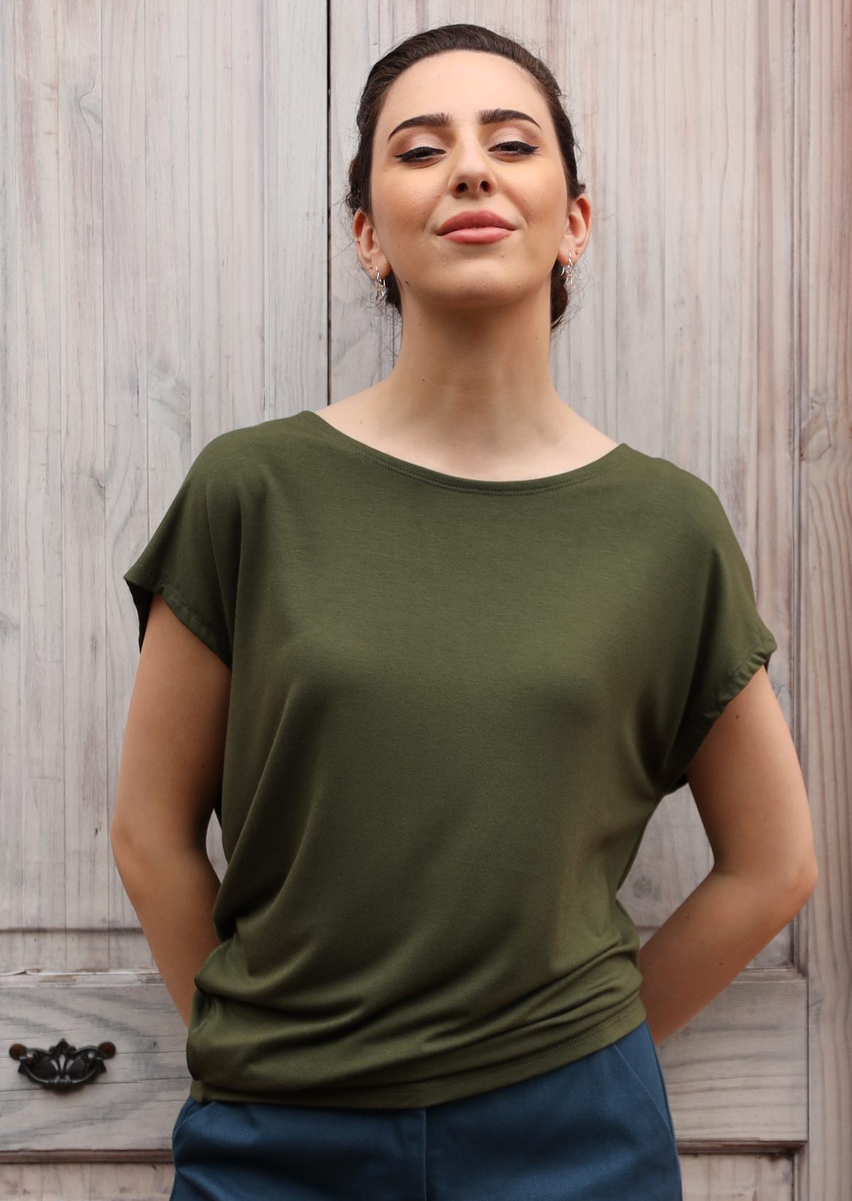 Woman wearing asymmetrical rayon olive green top