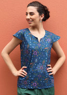 Model wears a short sleeve cotton top with a round neckline and keyhole cutout.  