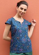 Model wears 100% cotton top with a floral print on a blue base. 