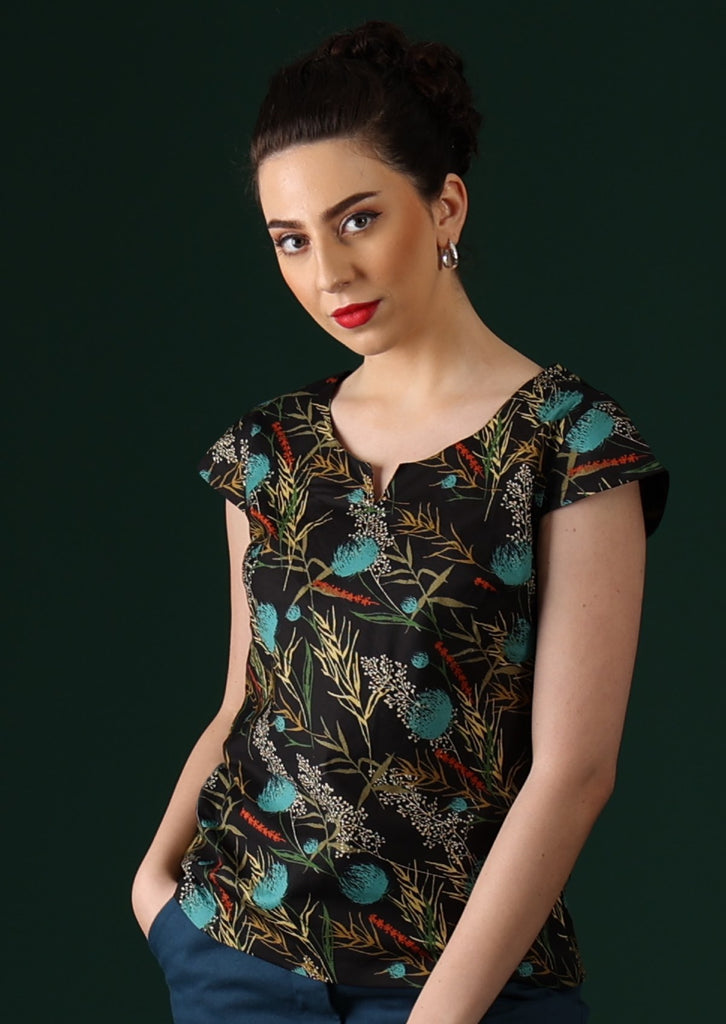 Model wears black based top with a blue and red floral pattern.