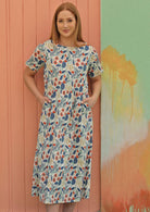 Model wears cotton dress with blue and soft red floral print on white base