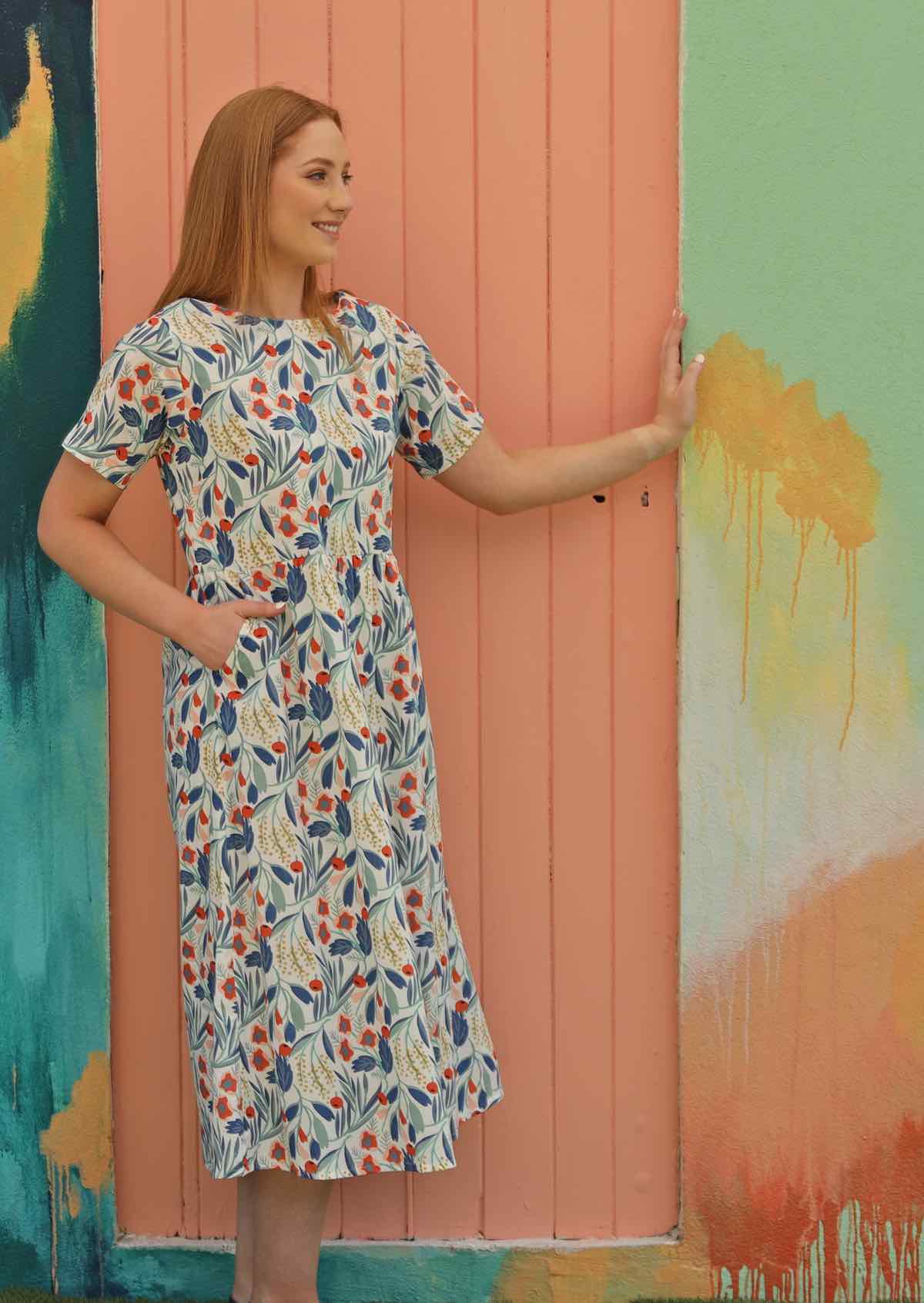 Model wears midi length cotton dress with short sleeves