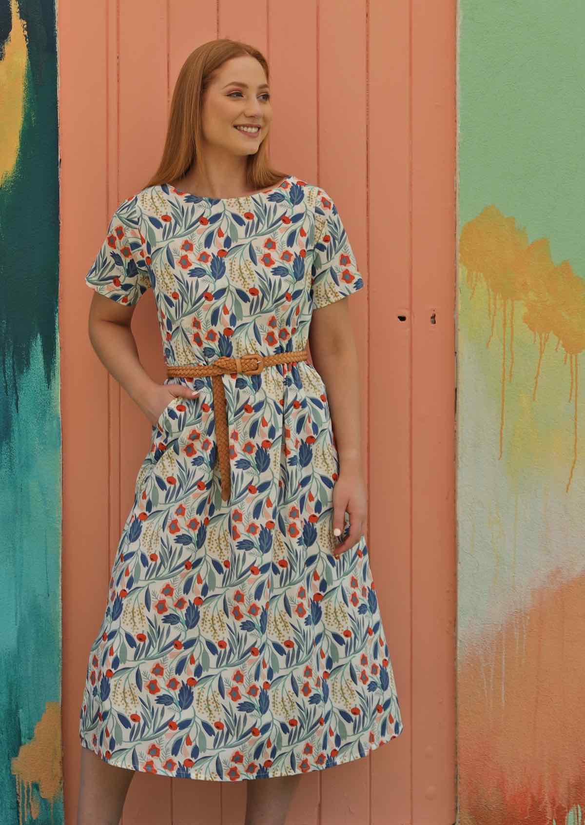 Model wears floral cotton dress with leather belt