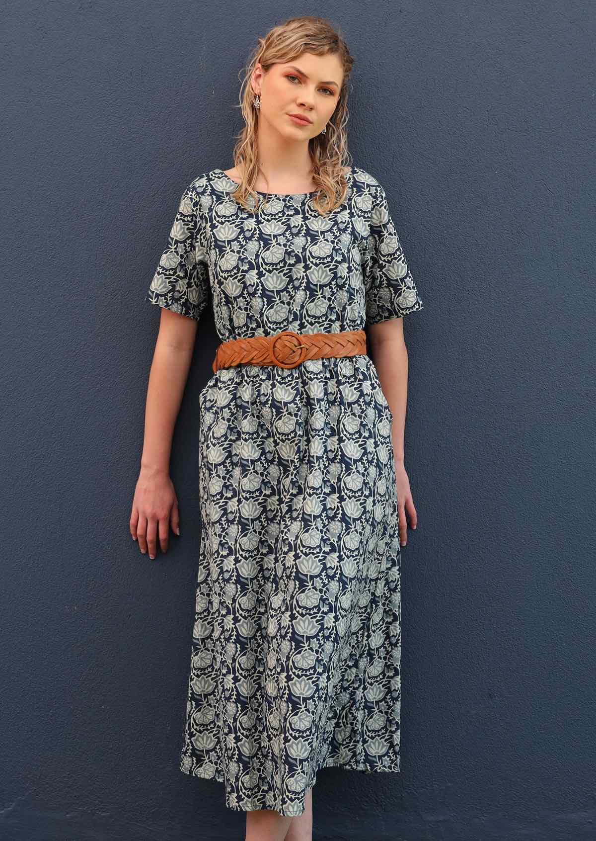 Model pairs loose fitting dress with a belt to cinch the waist. 