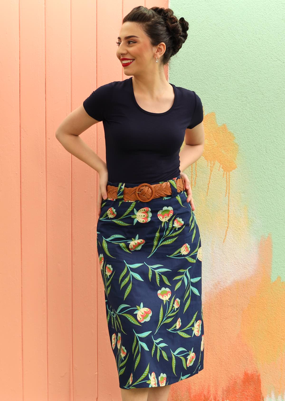 Model wears floral print skirt on a navy base.