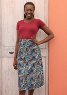 Model stands with her hand on her hip in a short sleeve top and cotton belt loop skirt. 