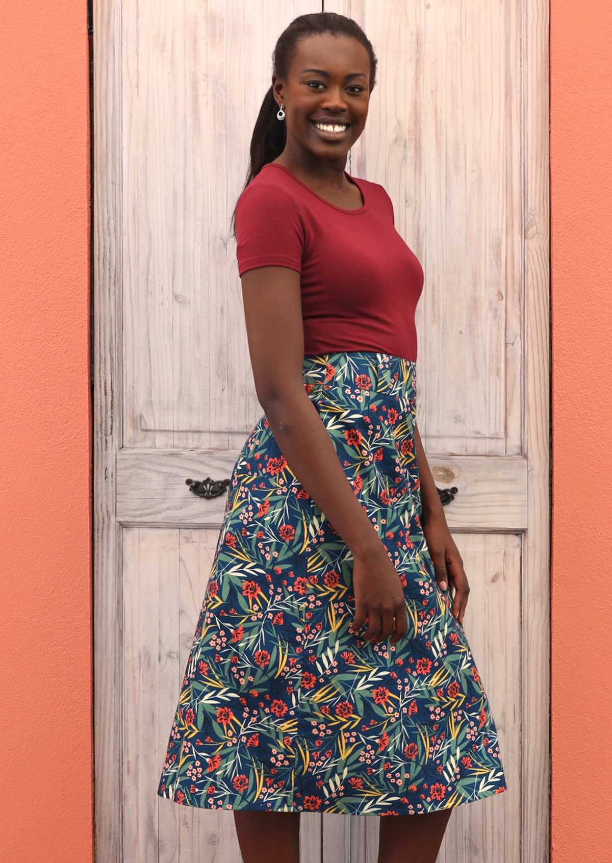 Smiling Model wears a skirt that has back pockets. 