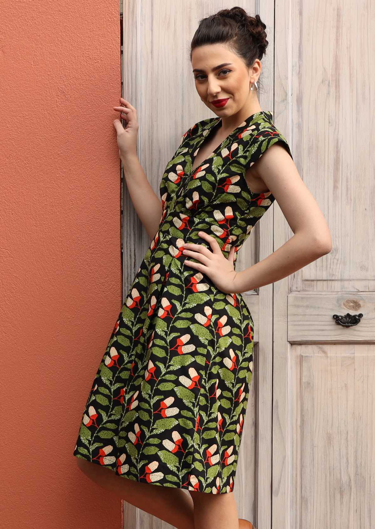 Model wears green and black knee length cotton dress