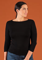 Woman wearing a rayon boat neck black 3/4 sleeve top