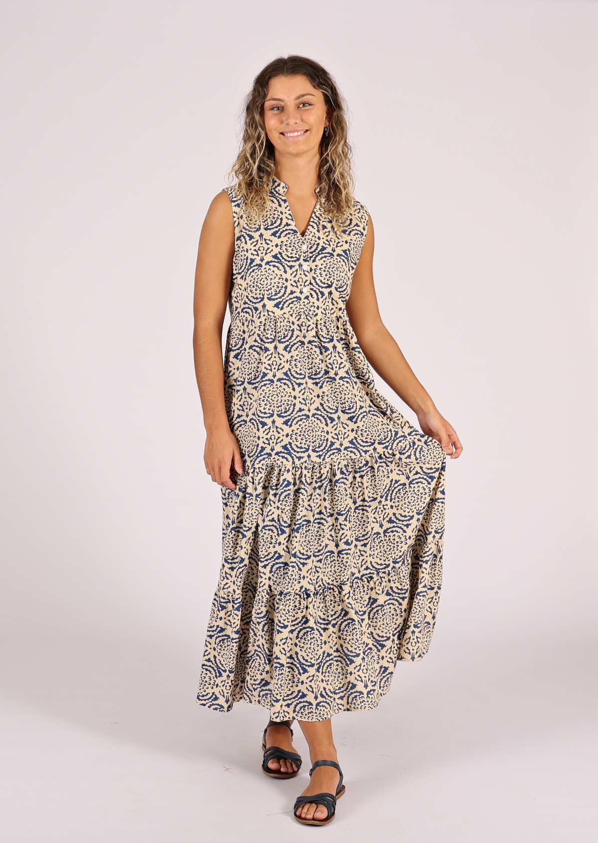 Model smiles in long cotton tiered dress with cream base