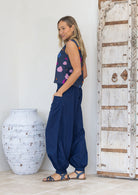 Woman wearing a navy blue sleeveless top with spotty print and navy blue wide-leg cotton pants