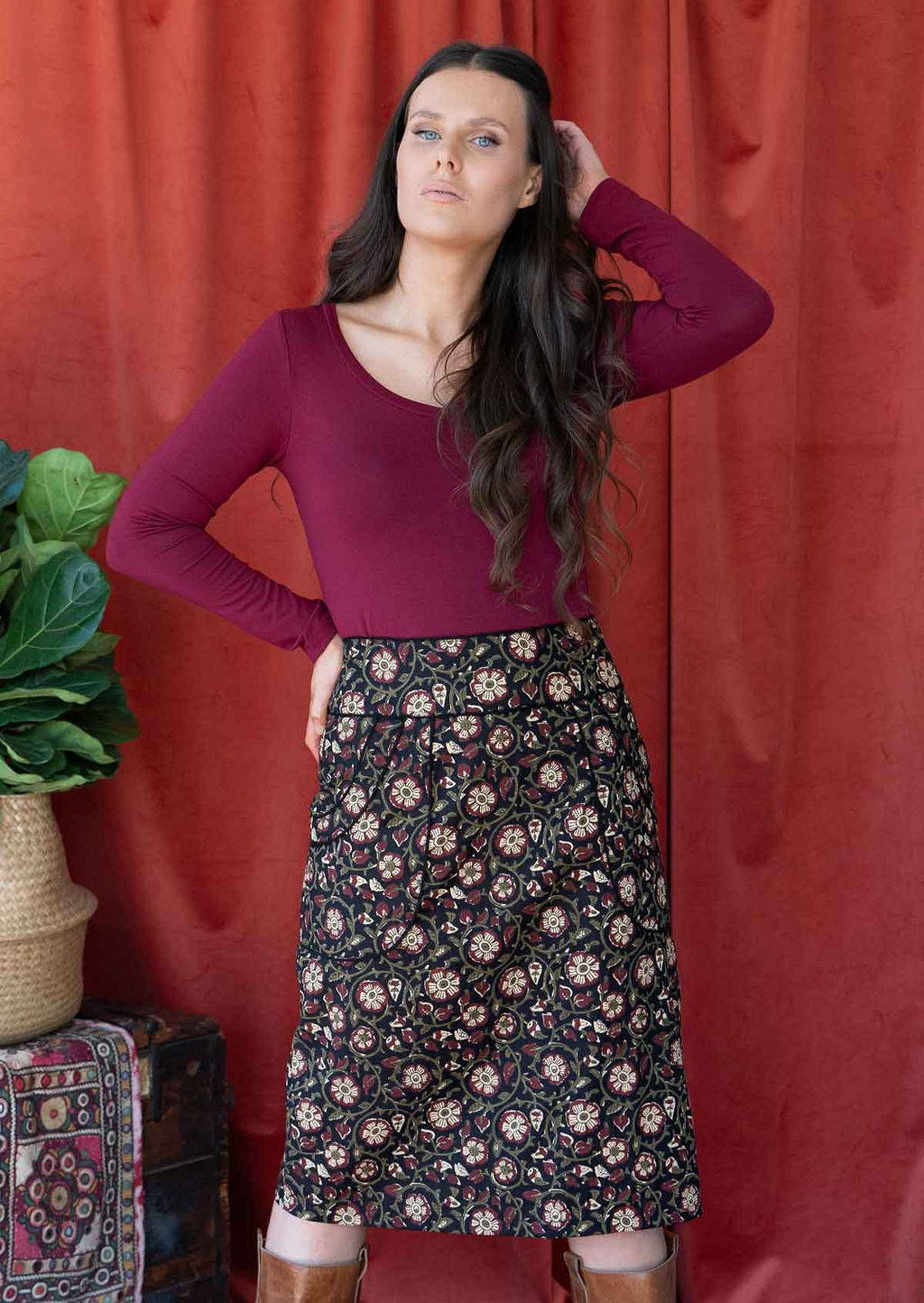 Model wears black based cotton pencil skirt with high waistband and piped details around pockets