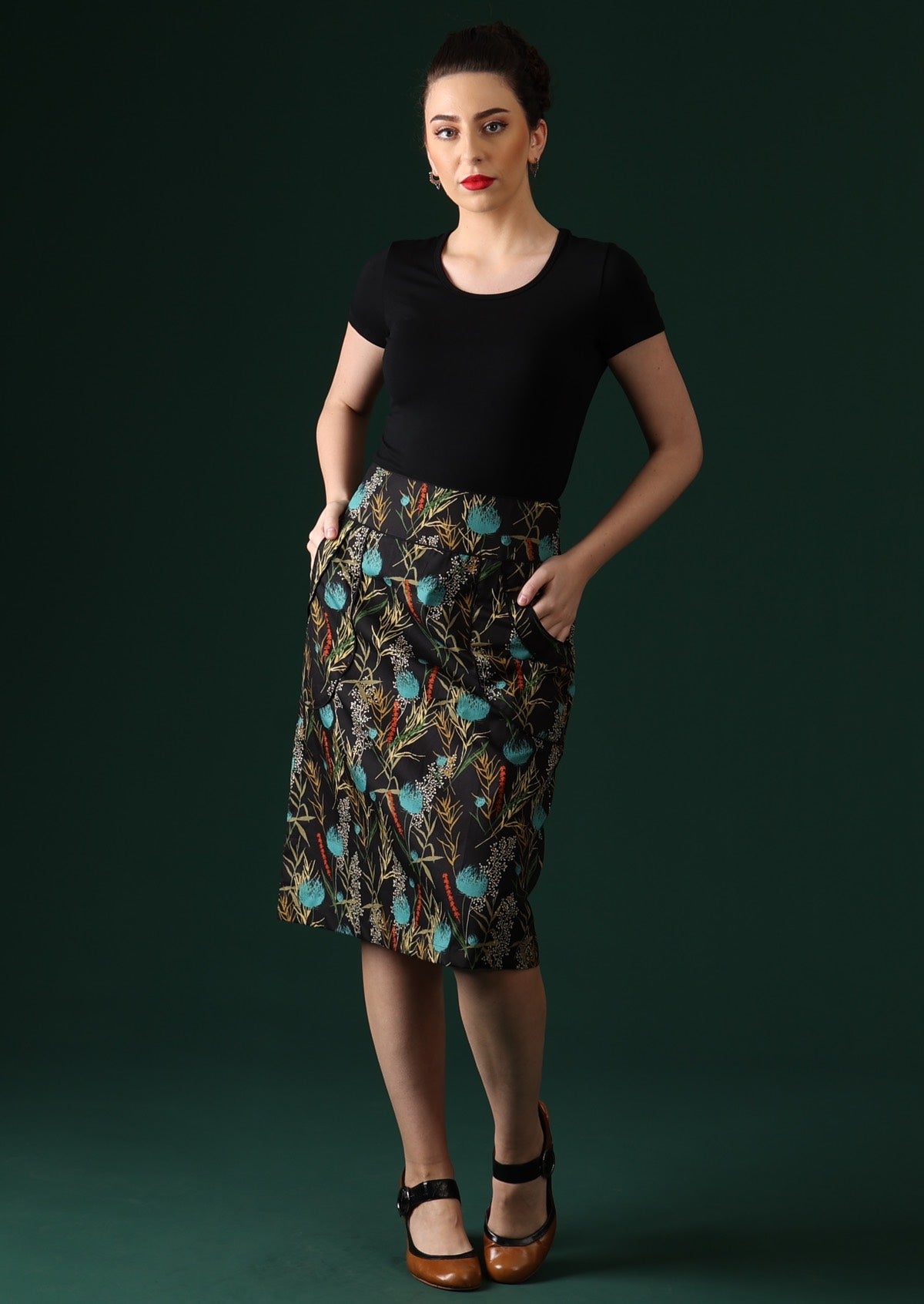 Model wears over knee length cotton pencil skirt with pockets