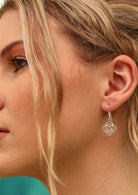 Silver dangly chakra earrings on woman with blonde hair