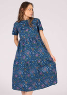 Model wears relaxed fit cotton dress with an empire waistline. 