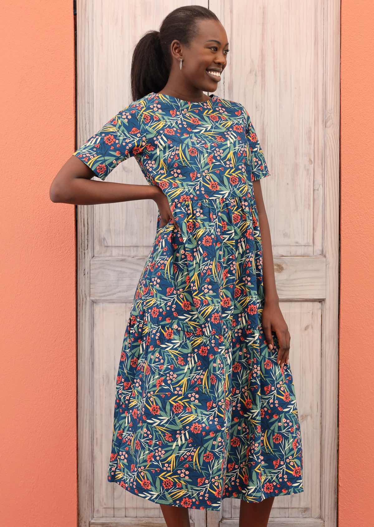 Model wears dress with a keyhole button back closure and hidden side pockets. 