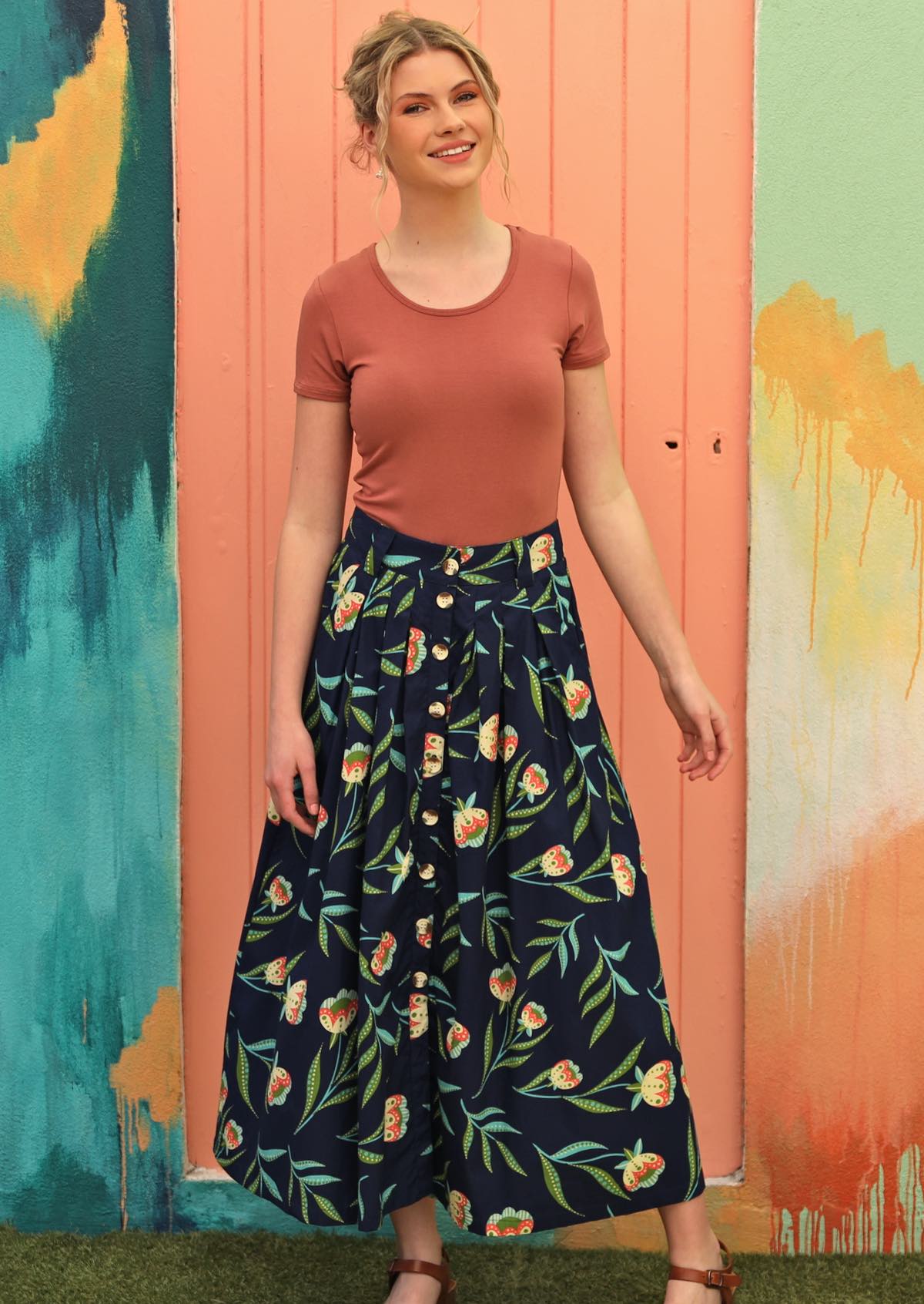 Model wears button through midi length skirt with floral print