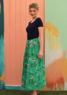 Model wears midi length cotton skirt with box pleats and belt loops