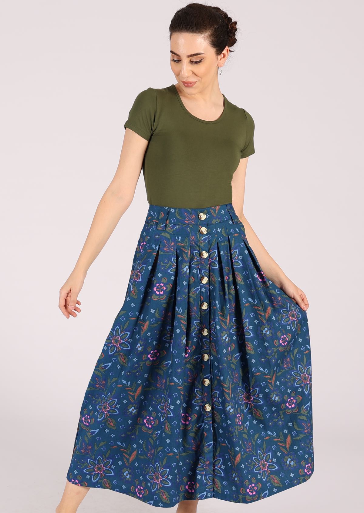 Model wears 100% cotton midi skirt with an orange, green and pink floral pattern on a blue base. 