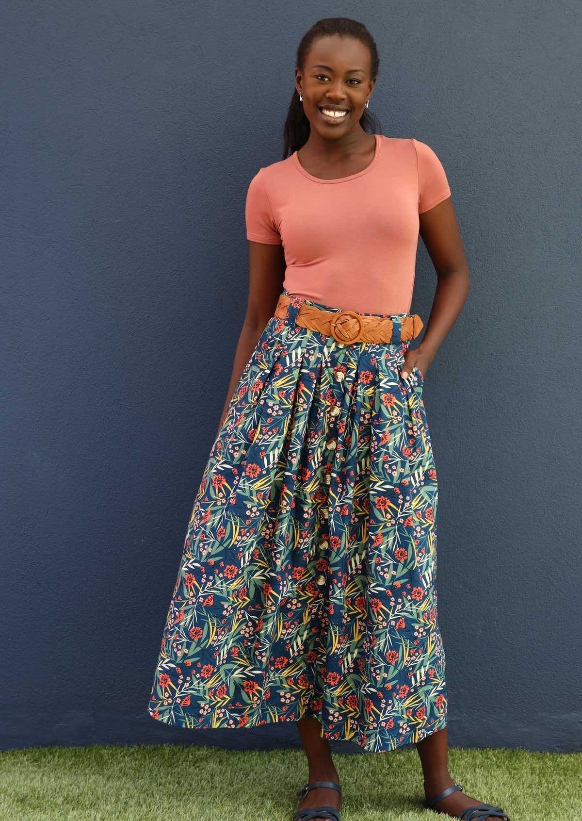 Model smiles in gorgeous blue floral midi length skirt