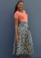 Model wears blue floral print cotton skirt with box pleats