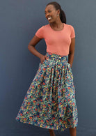 Model poses in cotton midi length floral print skirt with pockets