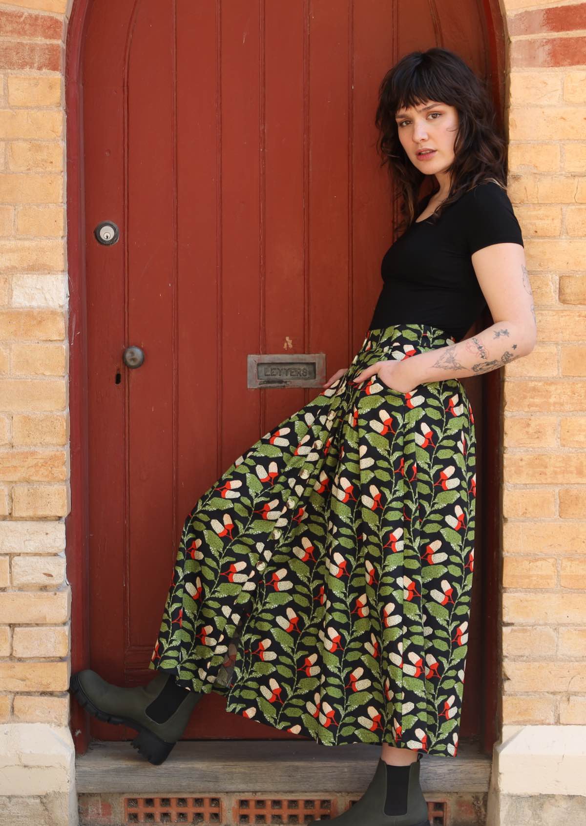 Model wears cotton skirt with box pleats, belt loops and pockets