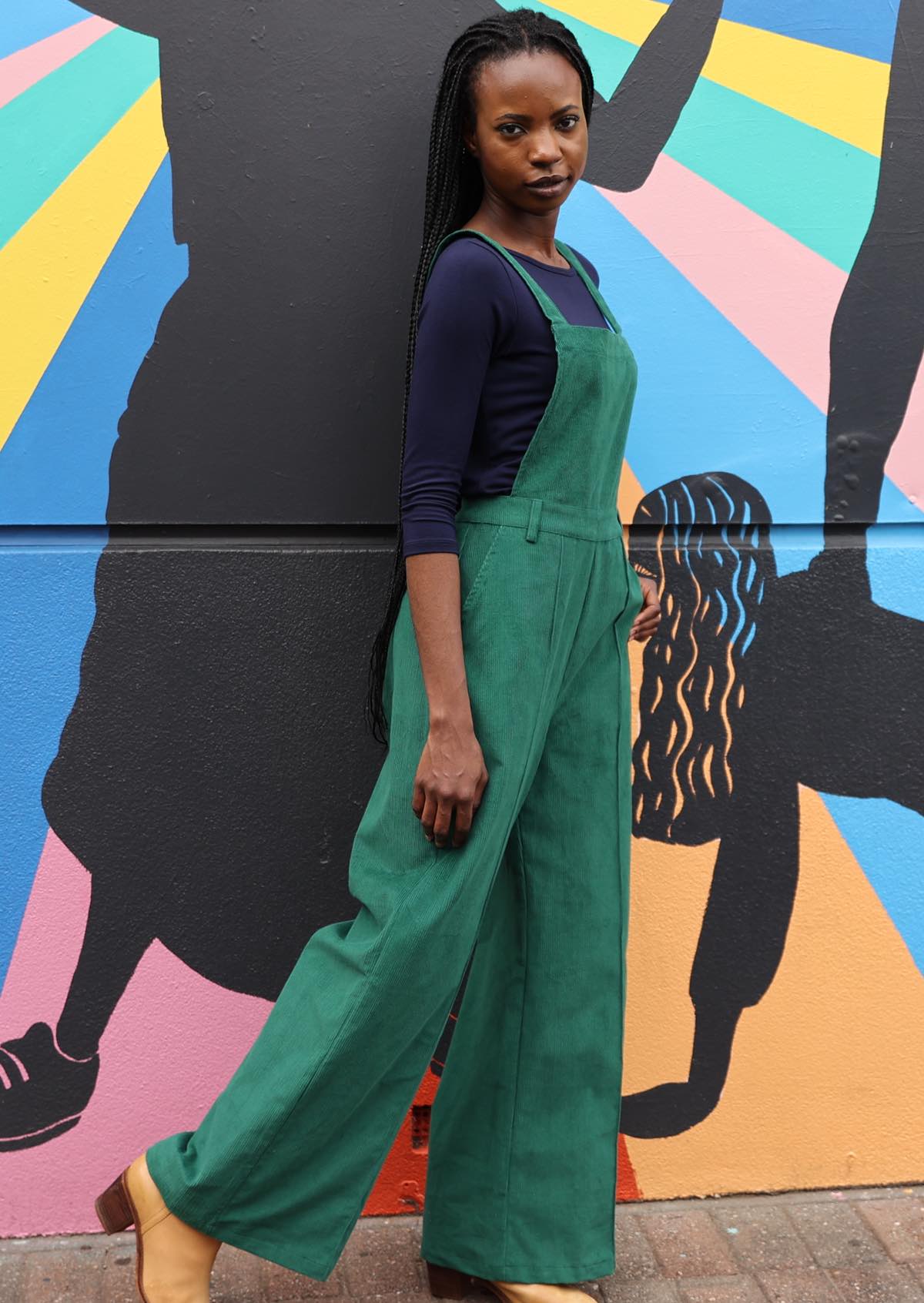 woman wearing green cotton corduroy overalls side view