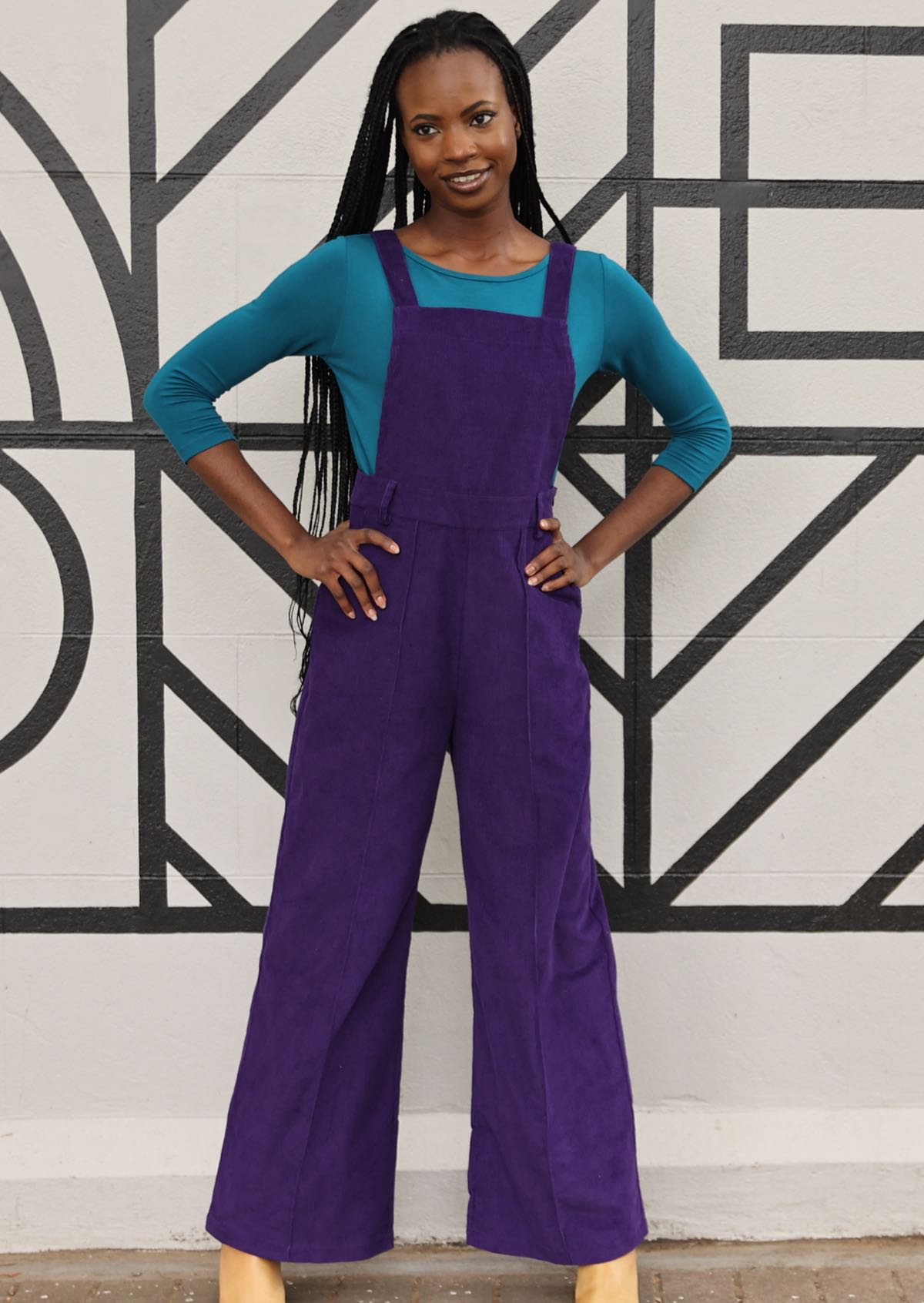 model wearing purple cotton corduroy overalls over teal long sleeve rayon top