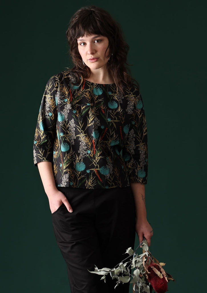 Model wears black base botanical print cotton boxy top with 3/4 sleeves and decorative buttons down the back | Karma East Australia