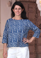 Model wears relaxed fit cotton top with 3/4 sleeves and round neckline in navy blue with off white floral print