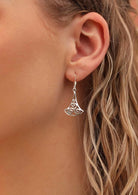 Silver celtic style earrings on blond woman