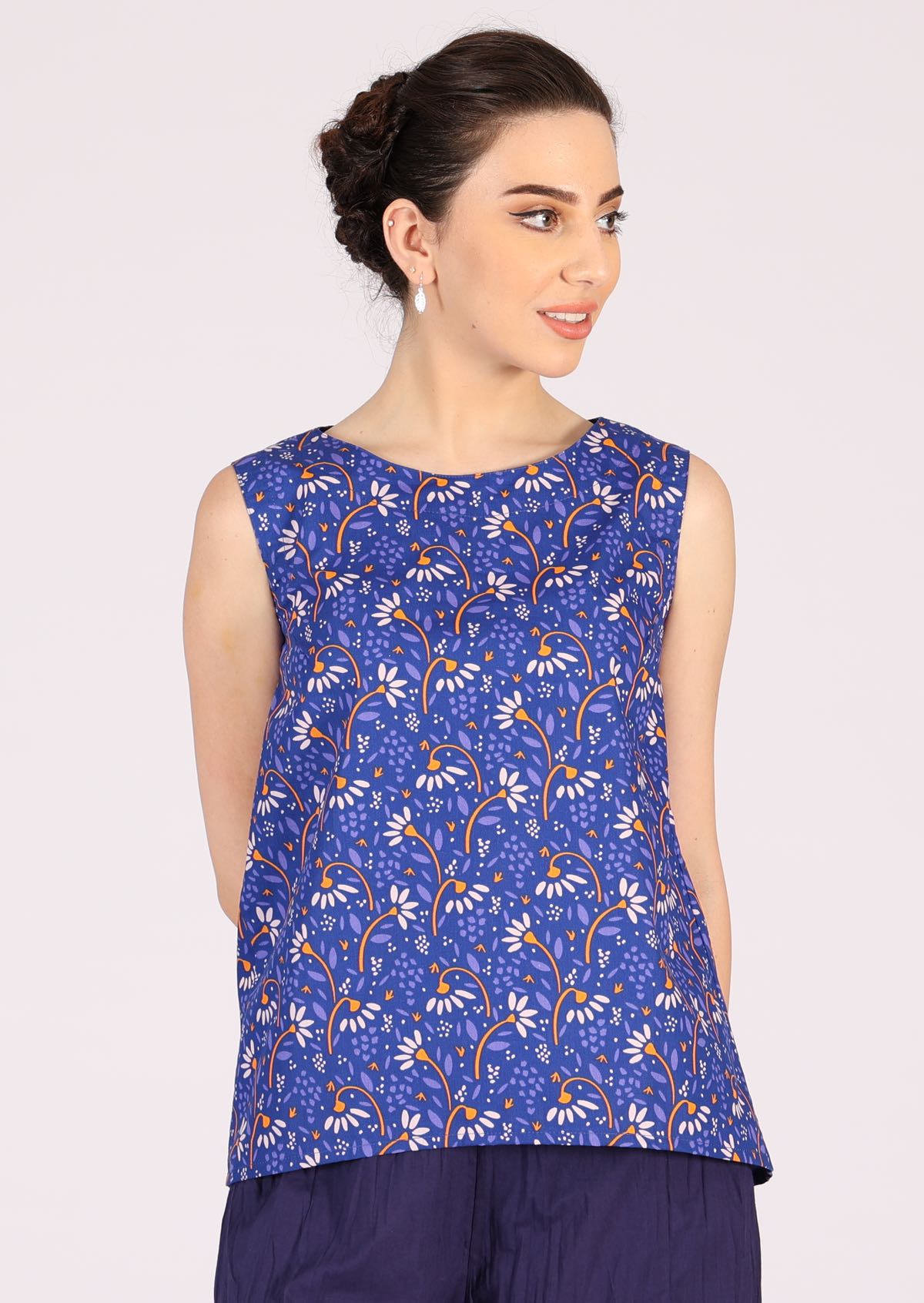 Model wears sleeveless cotton daisy print top