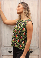 Model wears sleeveless cotton top with slightly concave front hem