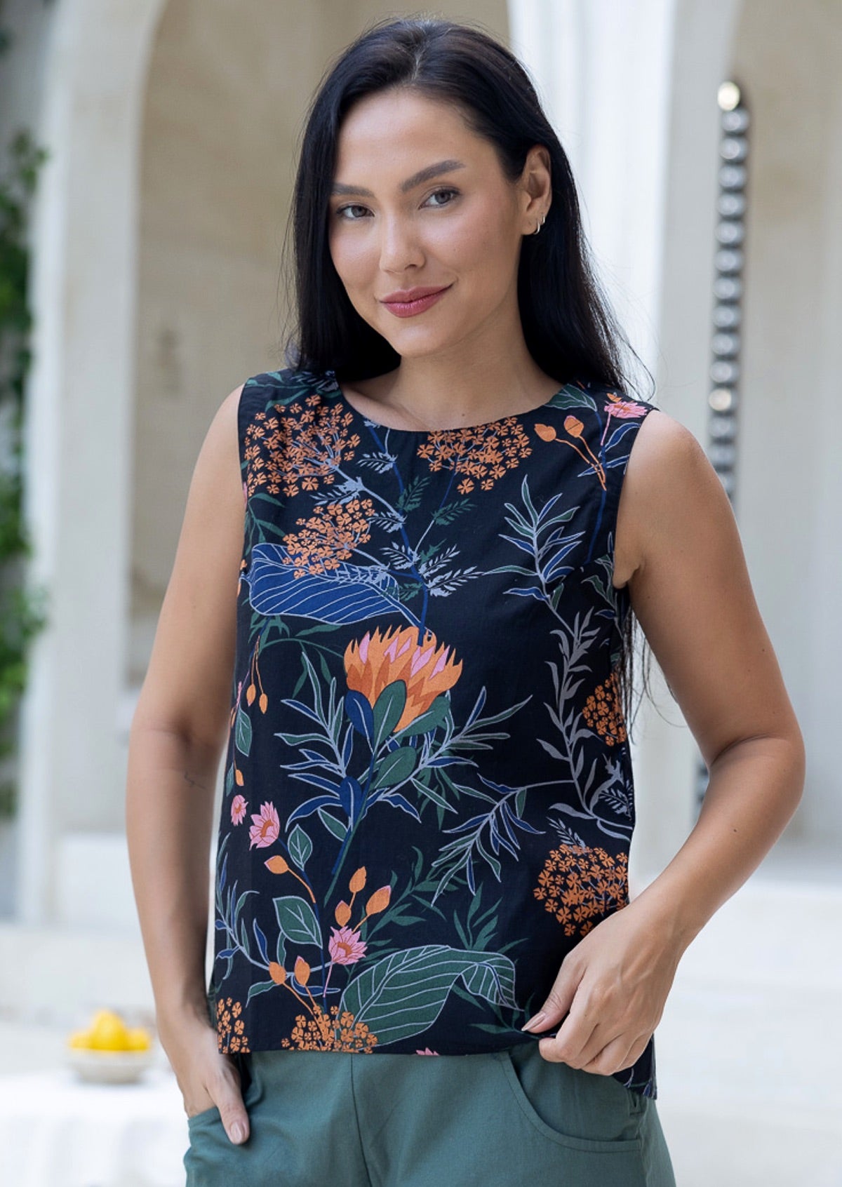 Woman in floral printed sleeveless cotton top with high round neckline and A line cut