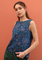 Sleeveless 100% cotton top features a floral print on a blue base. 