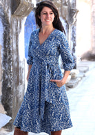 model wearing blue cotton wrap dress with hands in pocket