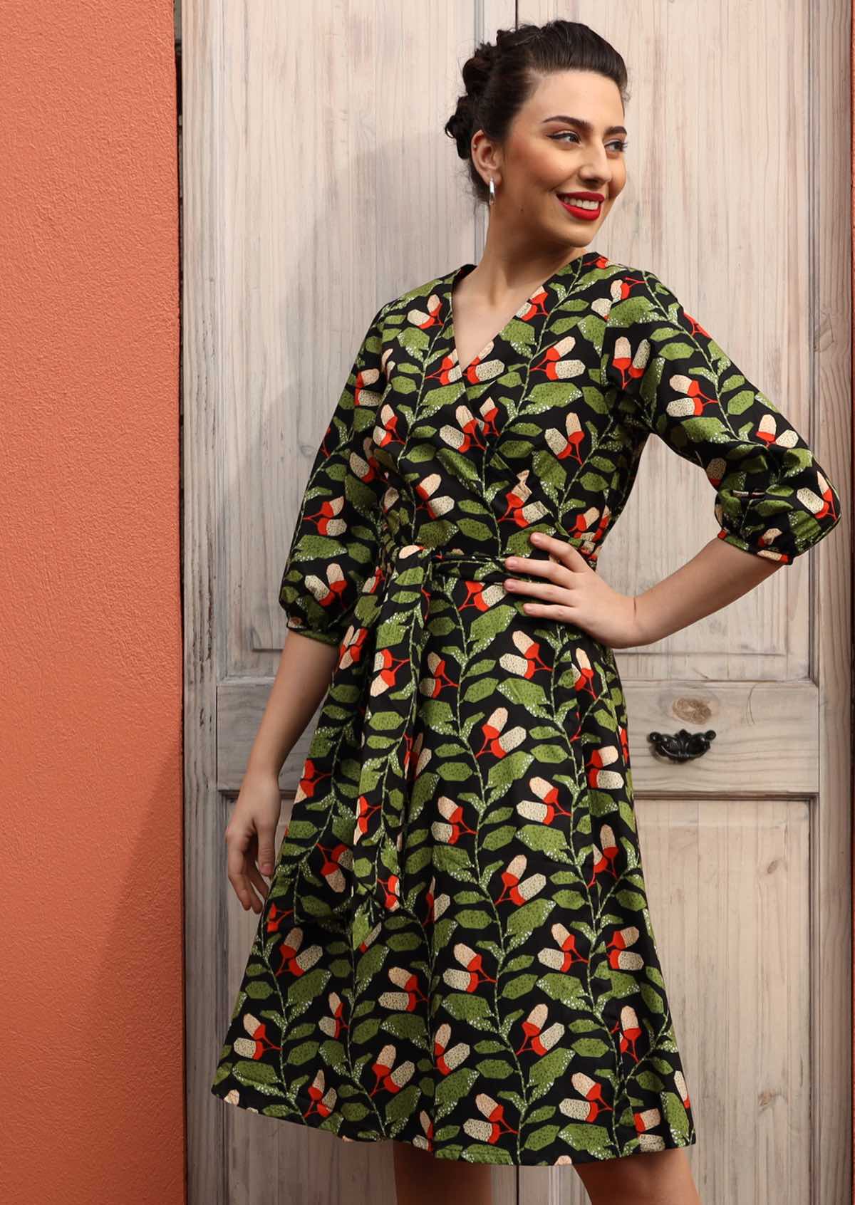 Model wears cotton wrap dress with 3/4 sleeves and wide waist tie