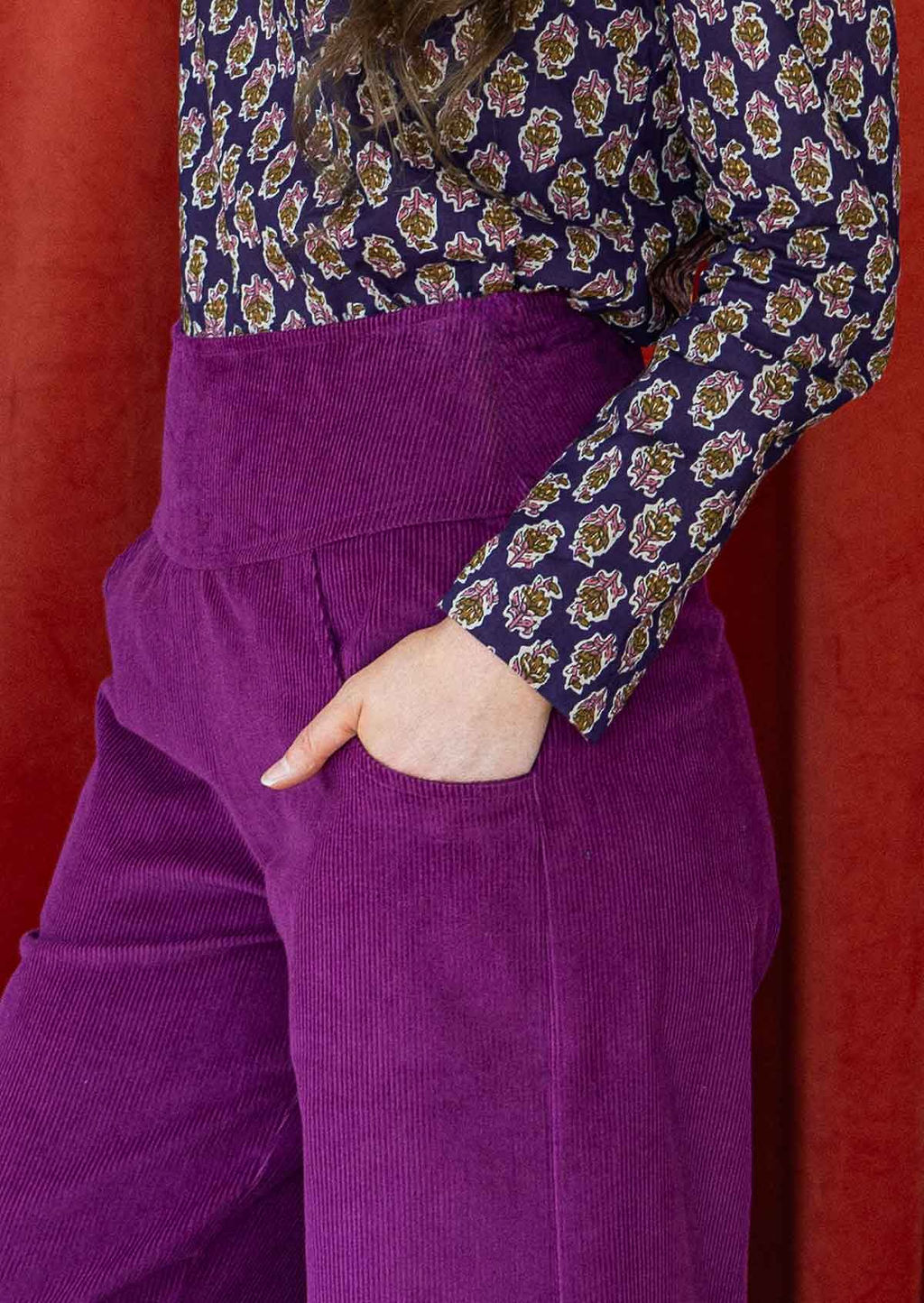 close up detail of hand in pockets of vibrant purple corduroy womens pants 