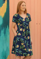 Red haired woman in navy blue floral cotton dress with pockets and v neck line 