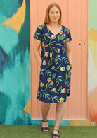 Red haired woman in navy blue floral cotton dress with pockets 
