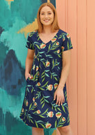 Red haired woman in navy blue floral cotton dress with v neck line 