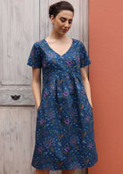 Model wears beautiful cotton dress with an empire waistline and small pin tucks. 
